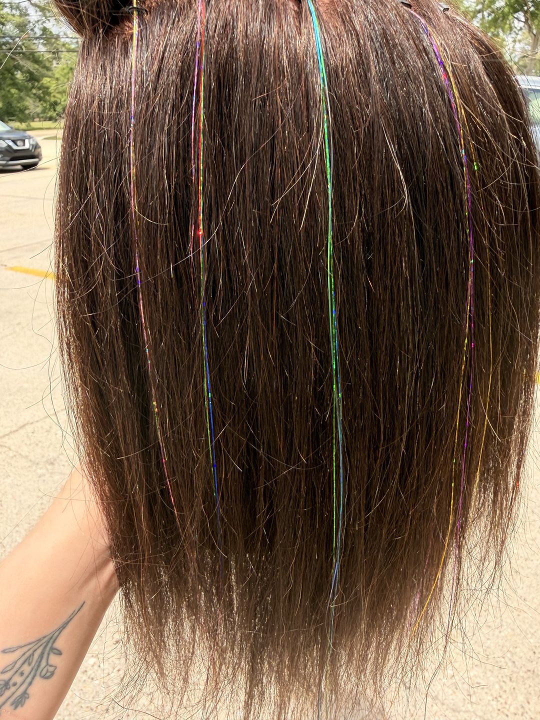 Hair tinsel sparkle strands woven into dark hair.